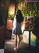 A woman standing in front of a wall with pictures on it.