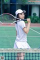 A woman holding a tennis racket on a tennis court.