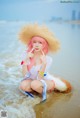 A woman in a straw hat sitting in the water.