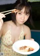 A woman holding chopsticks over a plate of food.