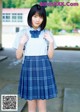 A young woman in a school uniform posing for a picture.