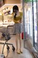 A woman wearing a face mask standing next to a shopping cart.