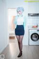 A woman in a blue and white outfit standing in a kitchen.