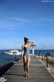 A woman in a bathing suit standing on a pier.