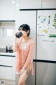 A woman standing in a kitchen holding a cup of coffee.