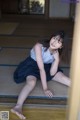 A young woman sitting on the floor in a room.