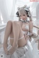 A woman in a white lingerie sitting on a chair.