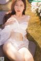 A woman in a white lingerie sitting on a bench.